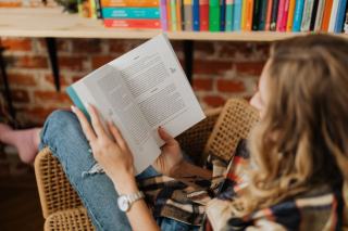 Livre ouvert et doigt suivant une ligne de texte